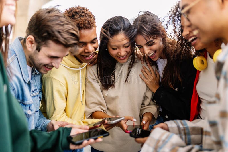 Young diverse friends laughing together looking at a phone